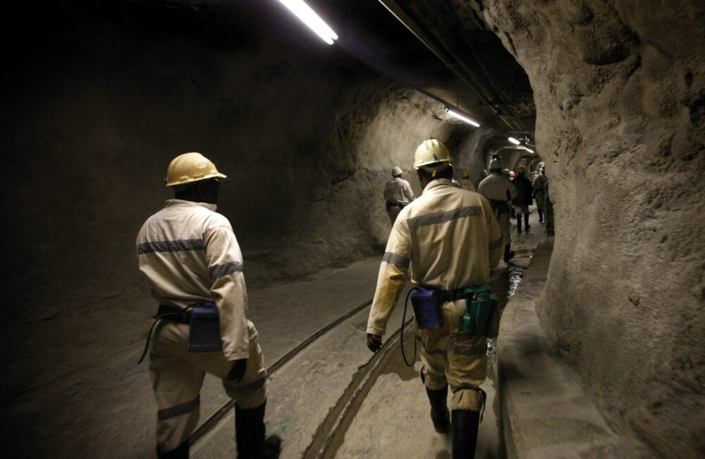 21 Feb 2007, South Africa --- TauTona gold miners walk from one elevator shaft to another to descend 2.8 kilometers (1 3/4 miles) below the earth surface, one of the deepest parts of the world's deepest gold mine. After traveling below ground shoulder-to-shoulder in three, 1 story elevators, the 150 miners travel by locomotive to their respective mine shafts. They than off-load and hike the rest of the way to climate controlled areas where they will work 8 hour shifts, 3 hours of which are break and travel.  Almost half of the laborers live on site, and live to scratch out an existence.The conditions are rough, and if not for massive air coolers, the workers would be digging in 130 degree Fahrenheit conditions, instead of a humid 85. For every ton of ore removed from the site, 12 grams of gold will be processed. The union laborers receive between 250-350 Ran, the equivalent of $35-50 per day. --- Image by © Tom Fox/Dallas Morning News/Corbis